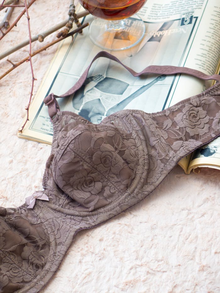 services-02 Stylish lace brassiere on vintage magazine background showcasing lingerie fashion.