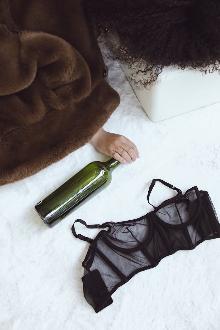 A fur coat, empty wine bottle, and lingerie hint at a carefree after-party moment.
